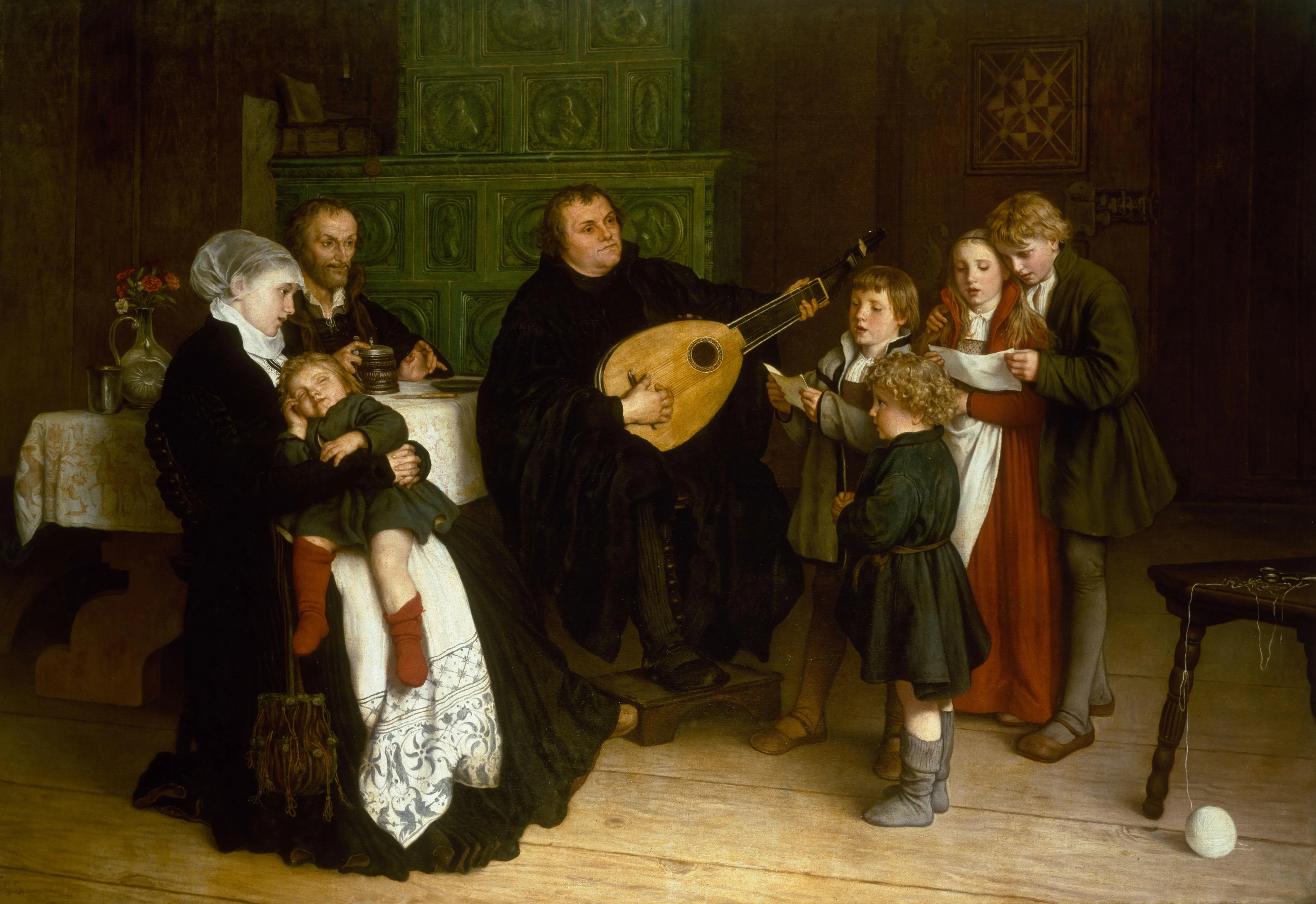 Martin Luther, in black robes, plays a lute at the center of a wood-paneled room; Katharina von Bora cradles a sleeping child at left, an older scholar (Philipp Melanchthon) sits at a table, and three children at right sing from a sheet beside a green tiled stove. by Gustav (Gustav Adolf) Spangenberg